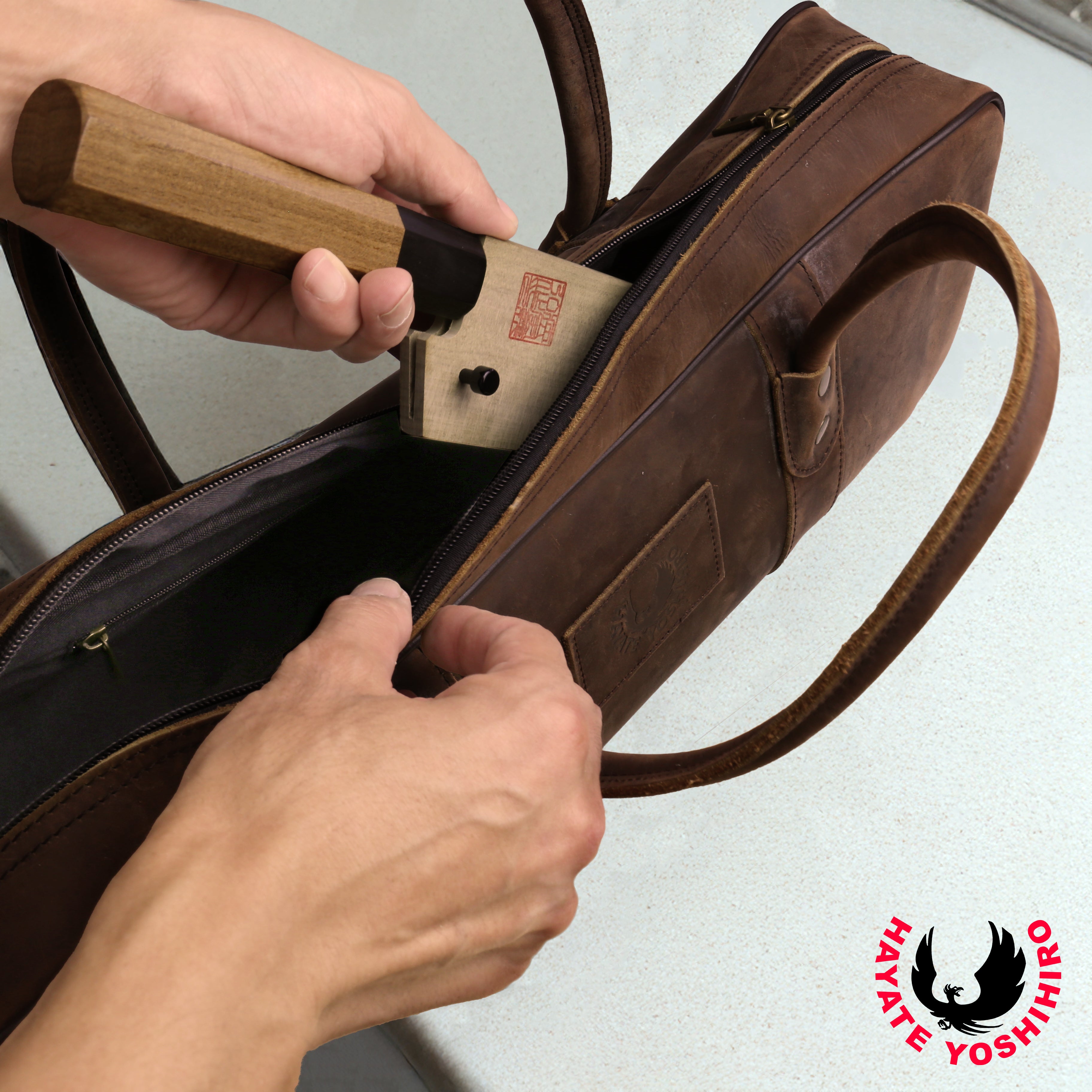 Brown leather knife bag with clasp open, revealing secured inner compartment