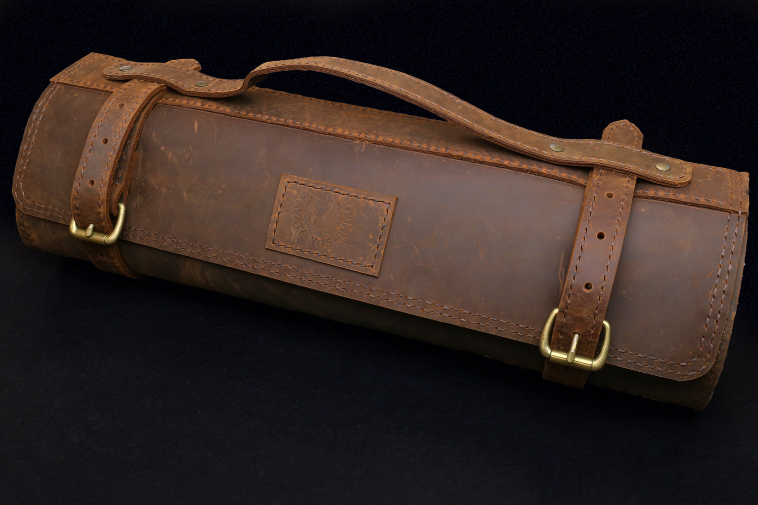 Brown leather knife roll case with handle strap and front flap patch