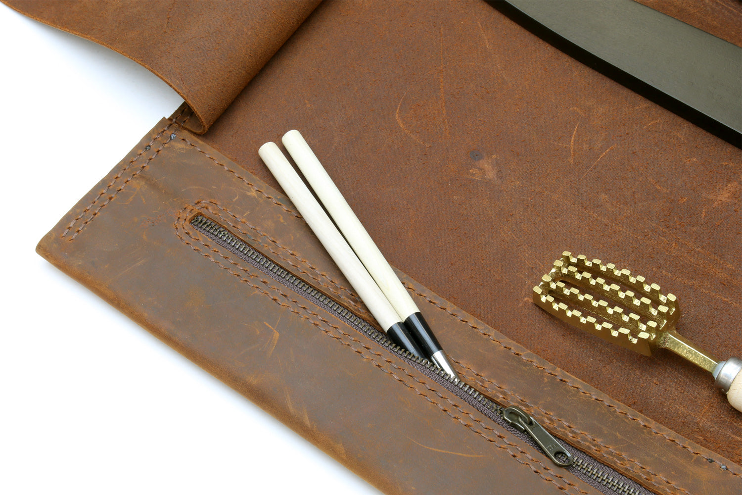 Brown leather knife roll case with tools and knives laid into interior pockets
