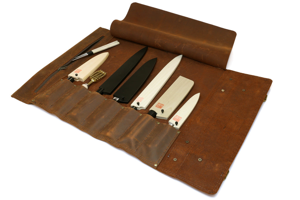 Brown leather knife roll case open with multiple knives secured in slots