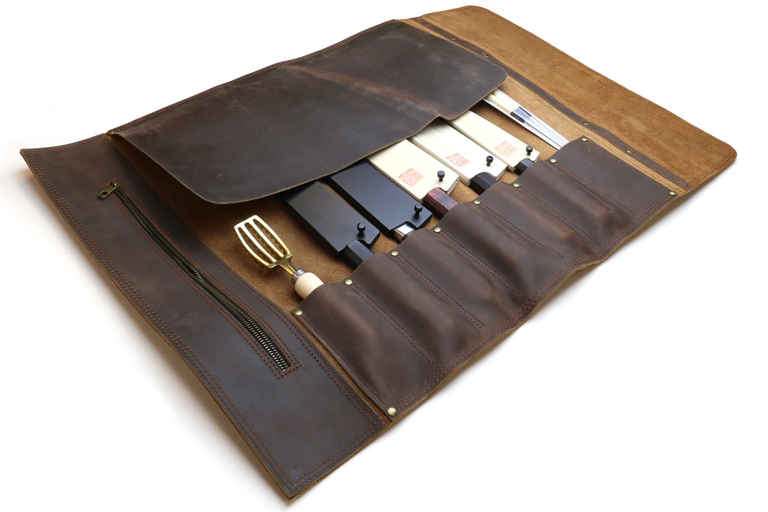 Brown leather knife roll case unfolded with interior sleeves and long front zipper pocket.