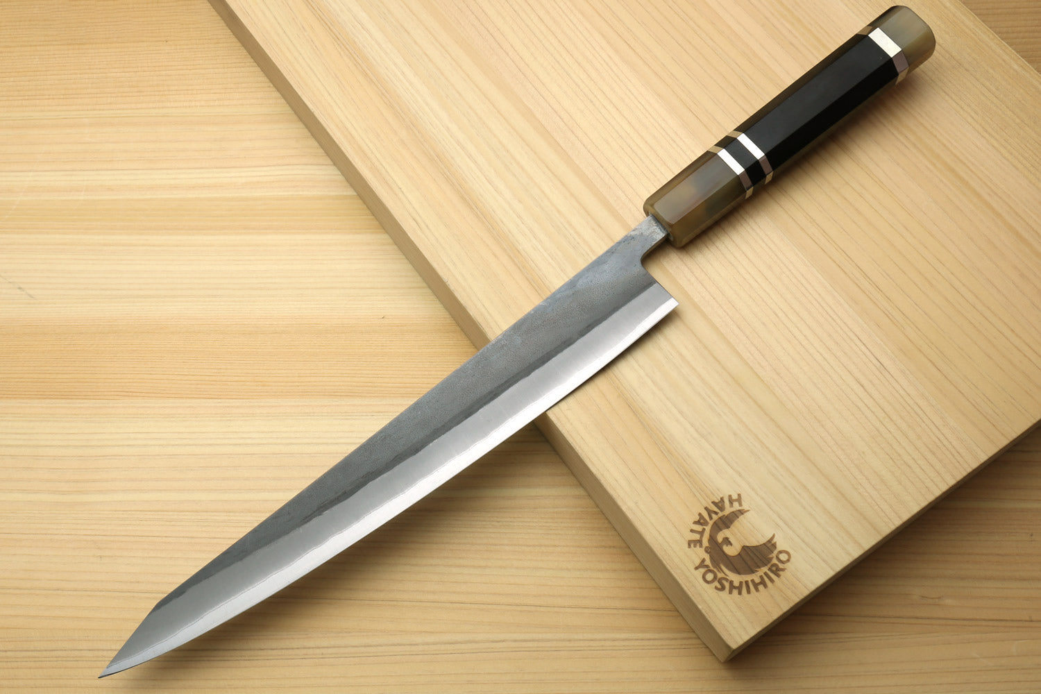 Kiritsuke slicer knife with black striped handle and pointed silver blade
