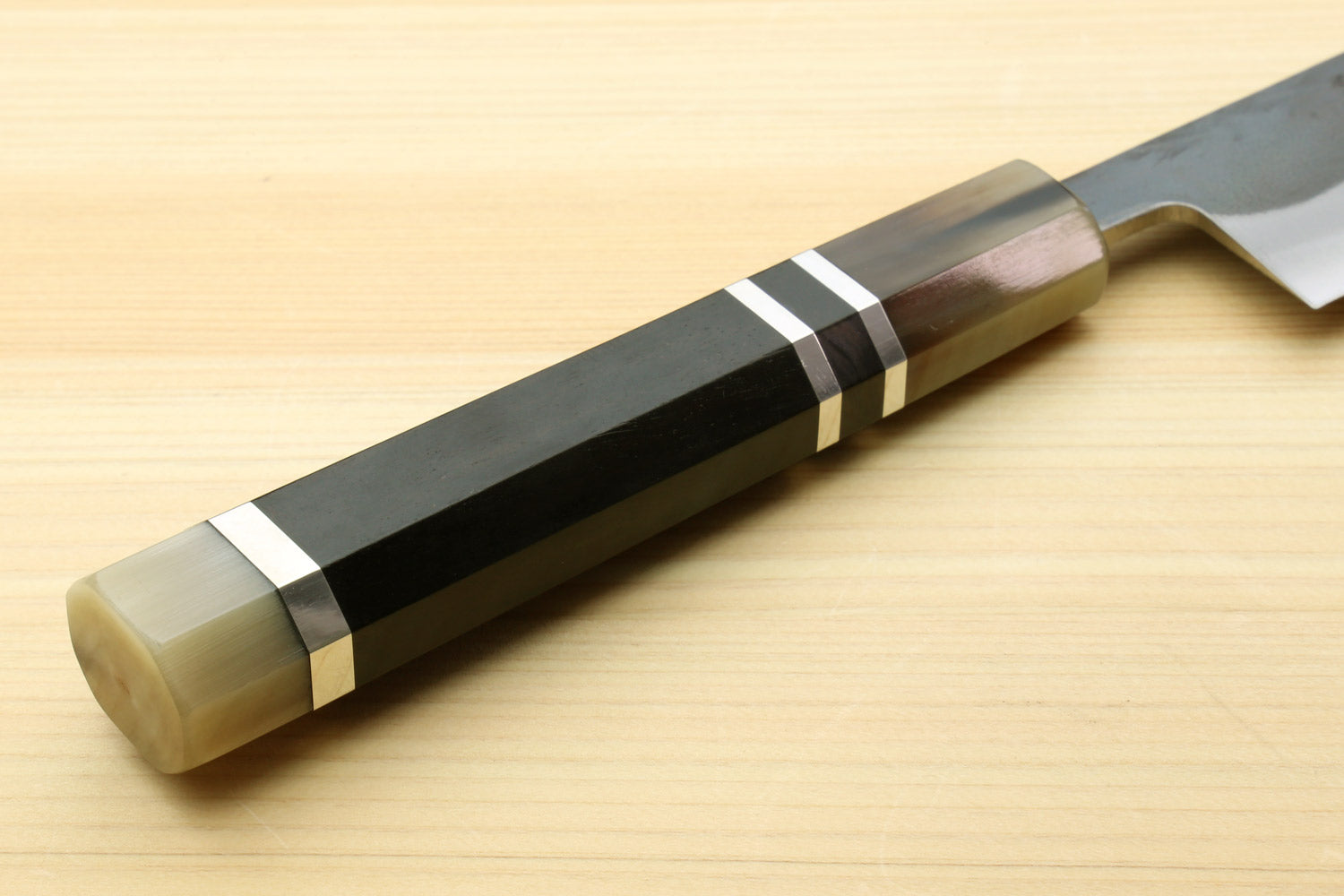 Kiritsuke slicer knife handle close-up with black bands and brass-toned ends