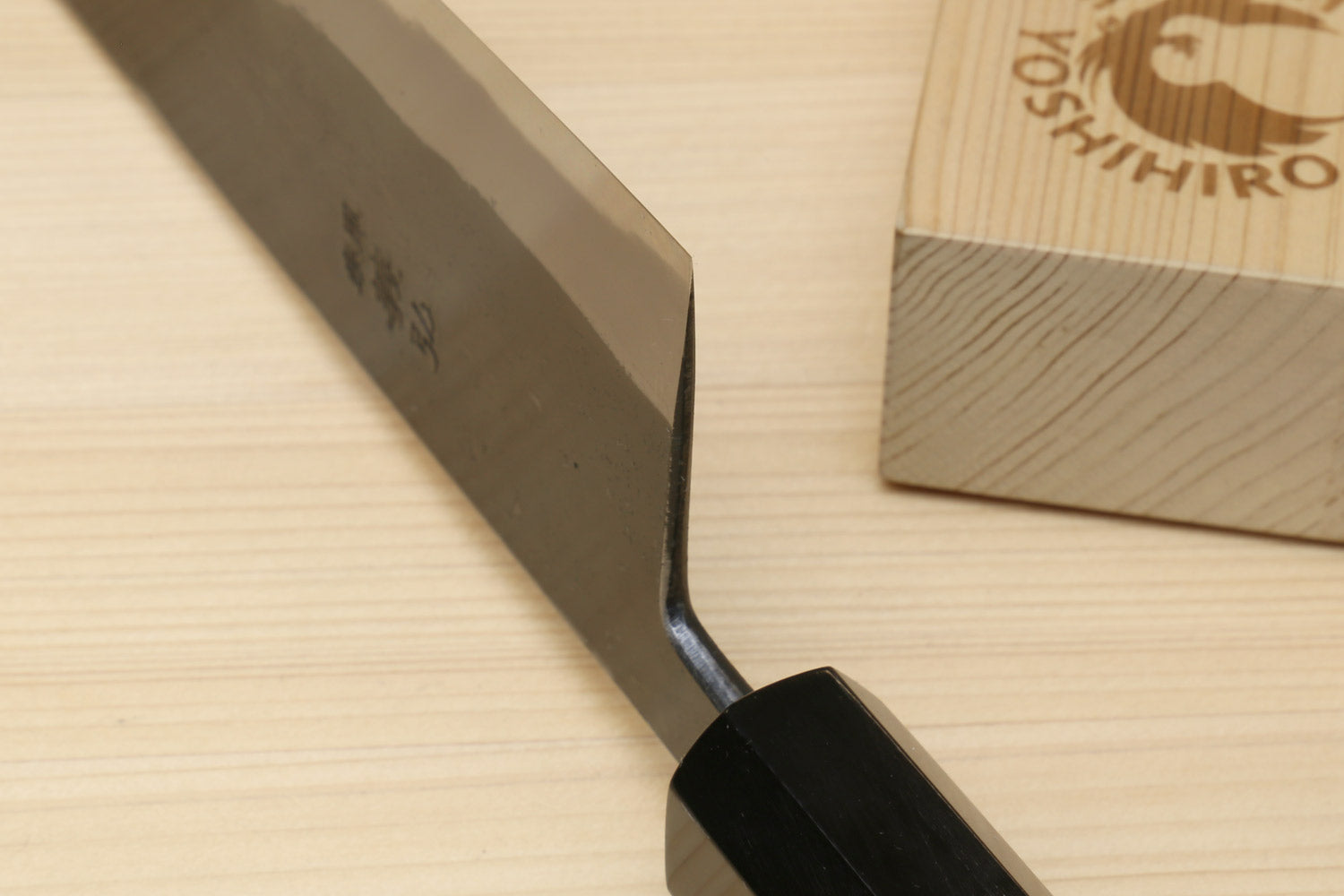 Japanese kiritsuke chef knife with dark kurouchi blade and black handle close-up