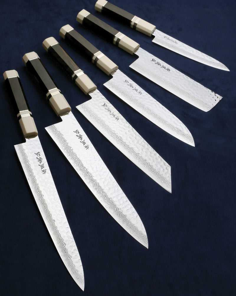Set of six chef knives on a dark background