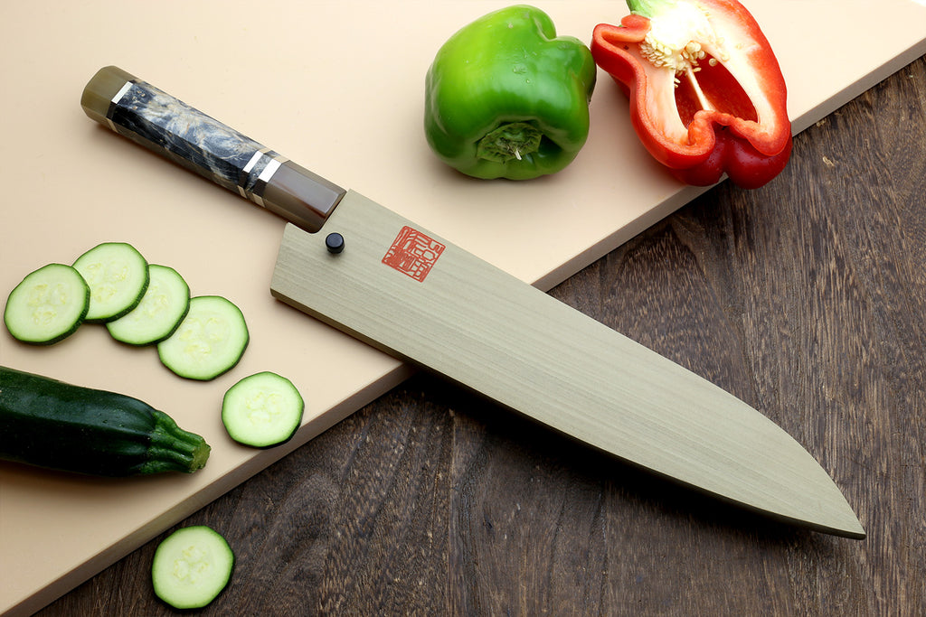 Gyuto chef’s knife with beige handle, dark blue mottled blade and striped bolster.