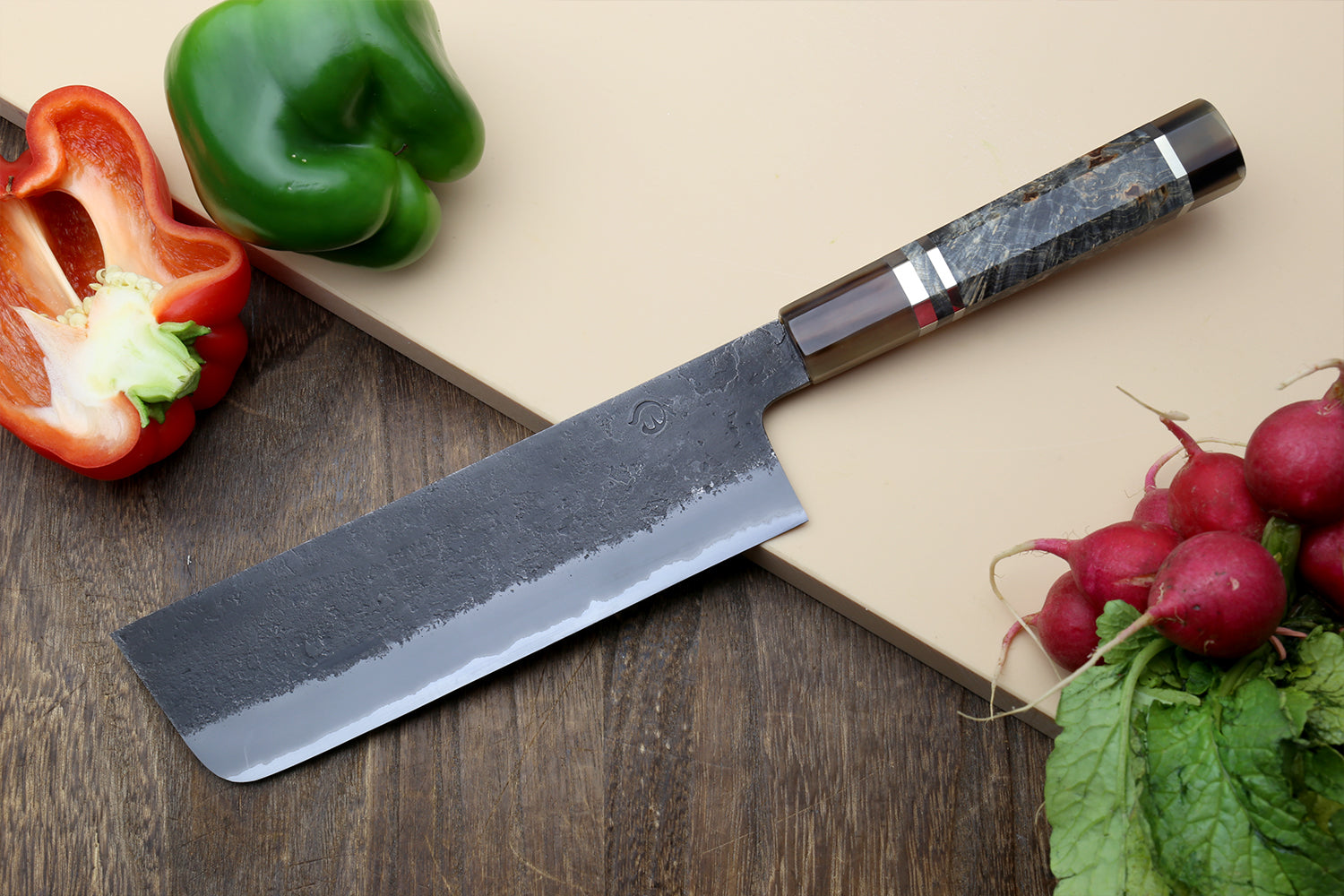 Nakiri vegetable knife on wood board with wide straight blade and dark handle cap
