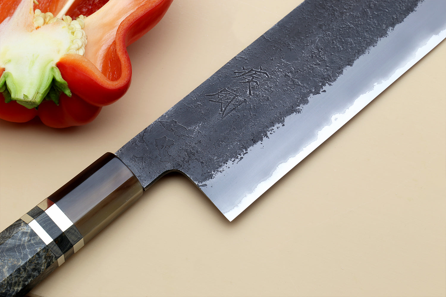 Nakiri vegetable knife with dark forged blade and distinctive offset bolster near handle