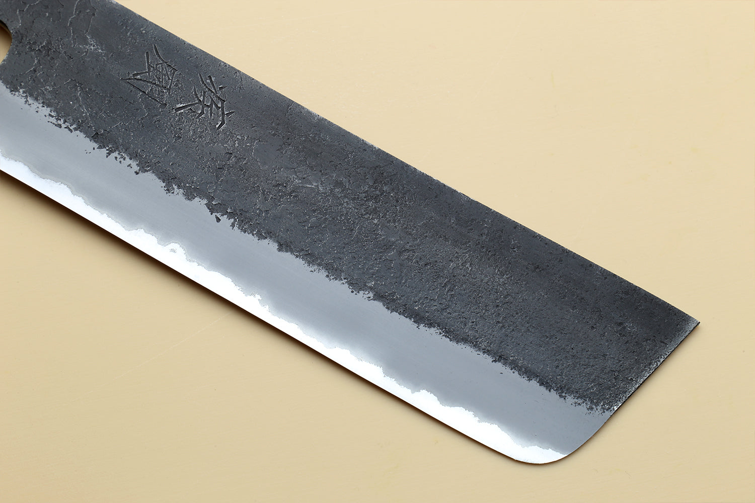 Nakiri vegetable knife blade tip and edge view with dark forged texture and silver bevel