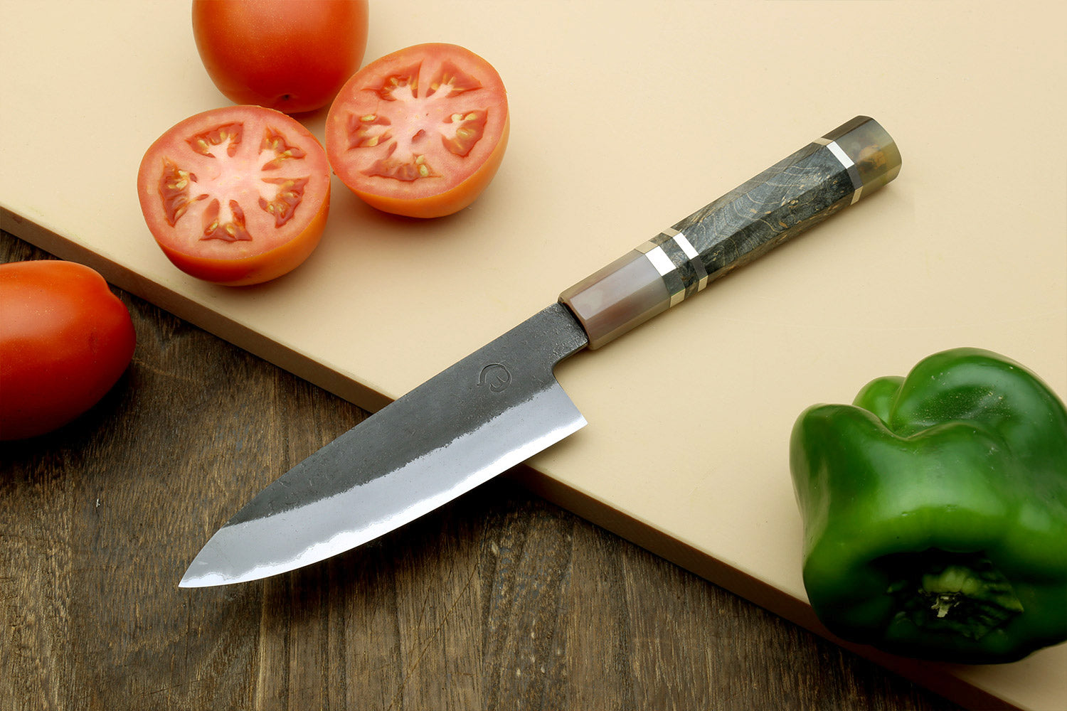 Paring knife with curved tip and silver blade, dark wood handle and bolster.
