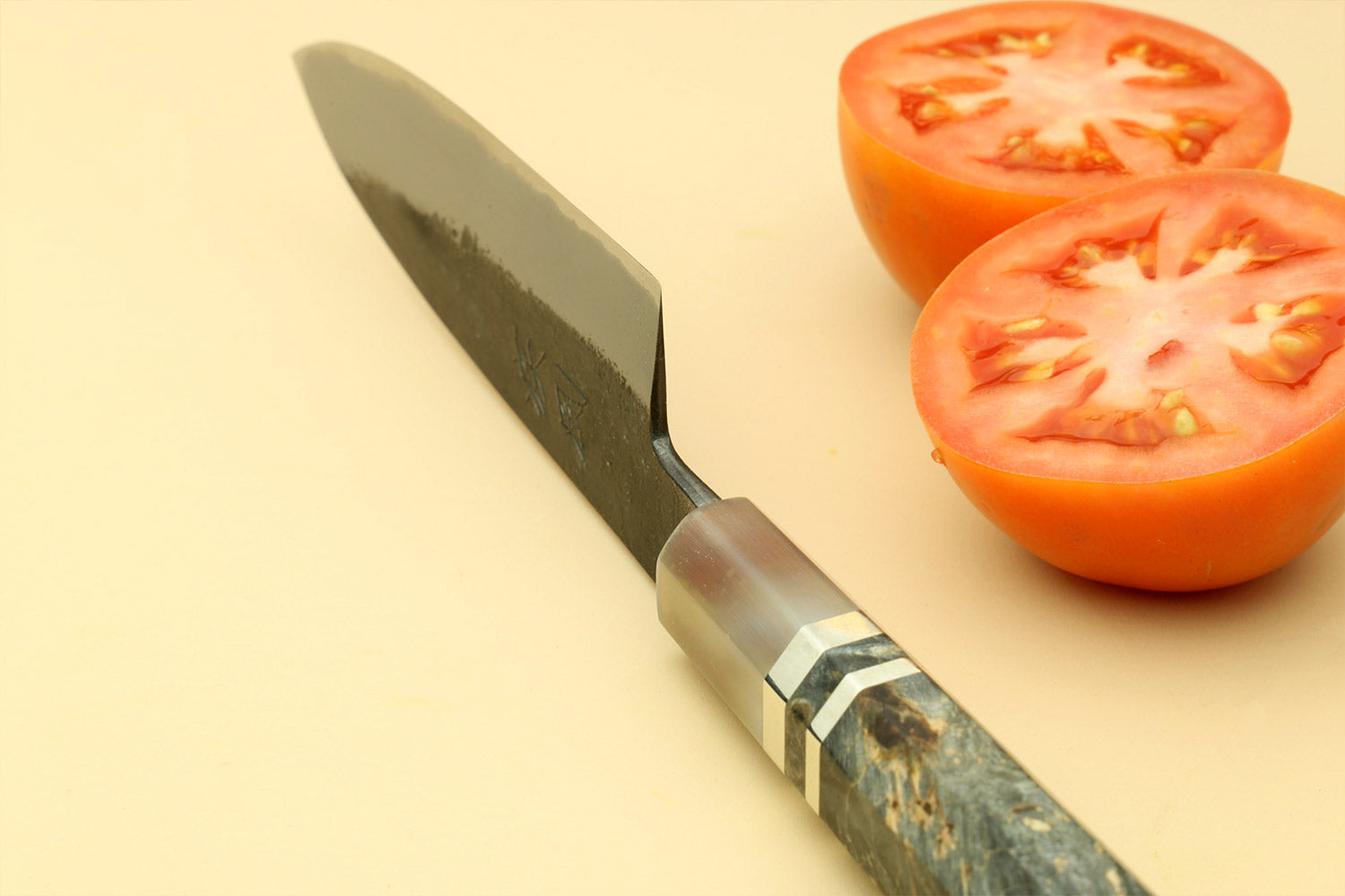 Paring knife with pointed tip, silver blade and dark wood handle, stamped logo.