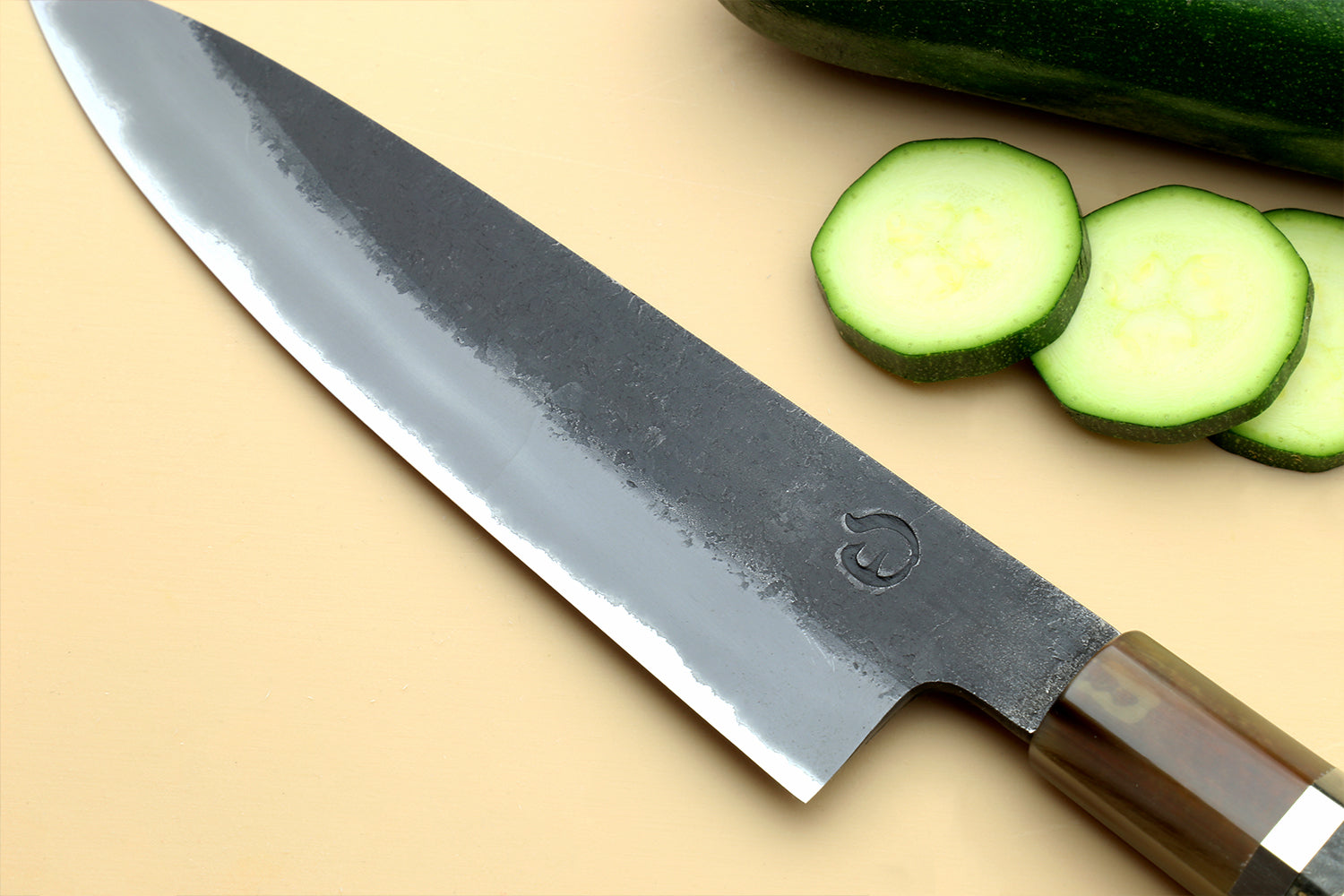Petty utility knife blade close-up with dark finish and wood handle