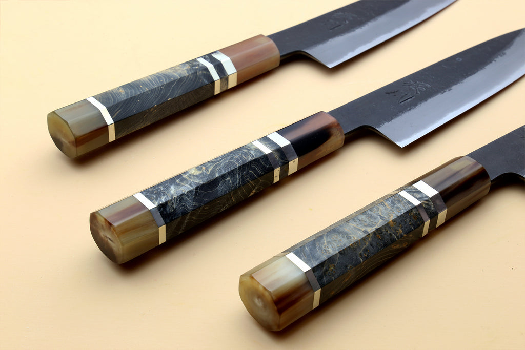 Three petty utility knives with dark blue steel blades and wood handles