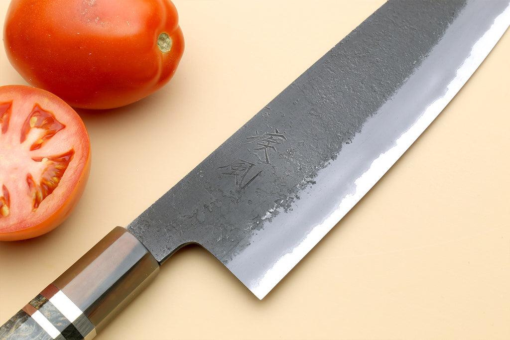 Close-up Santoku knife blade with hammered texture and blue steel finish