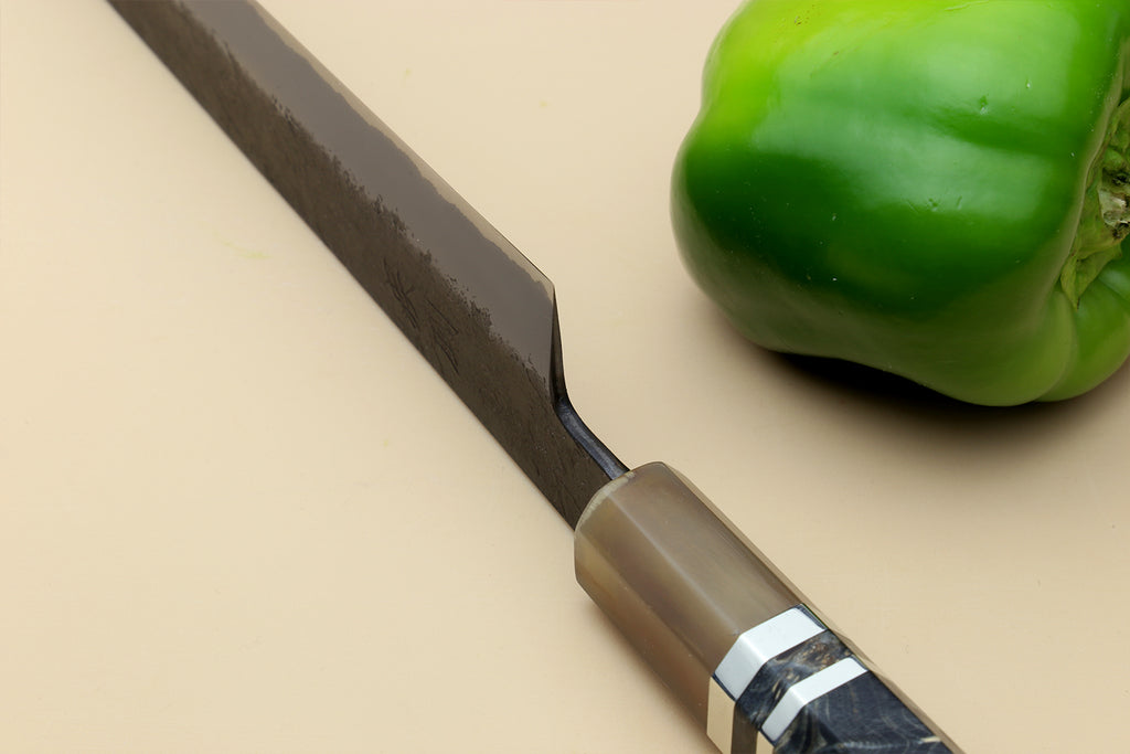 Sujihiki slicer knife handle close-up, dark blue steel blade and bronzed bolster