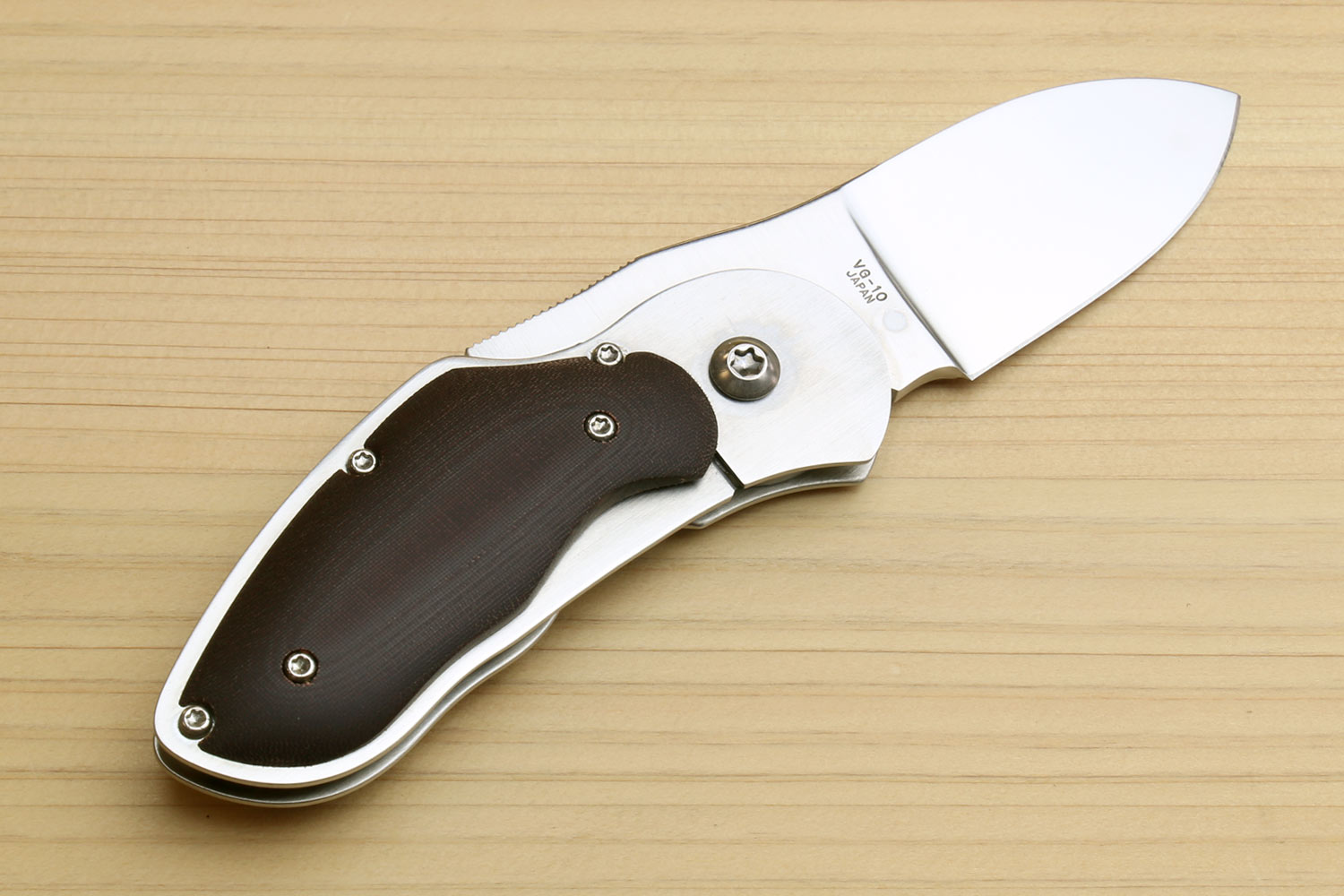 Folding pocket knife with open stainless blade and dark brown handle, gold emblem