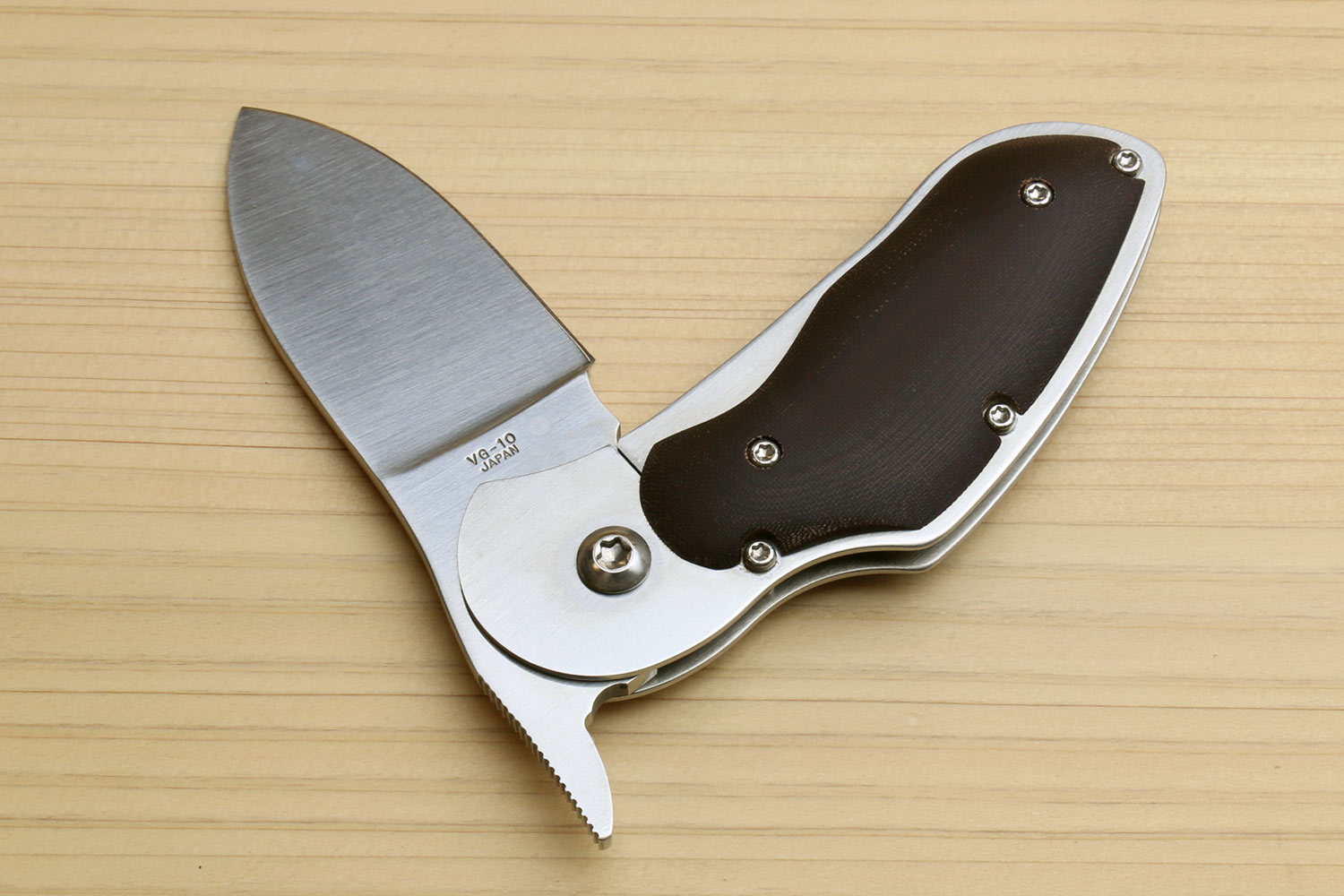 Folding pocket knife with open stainless blade and dark brown handle, metal pins