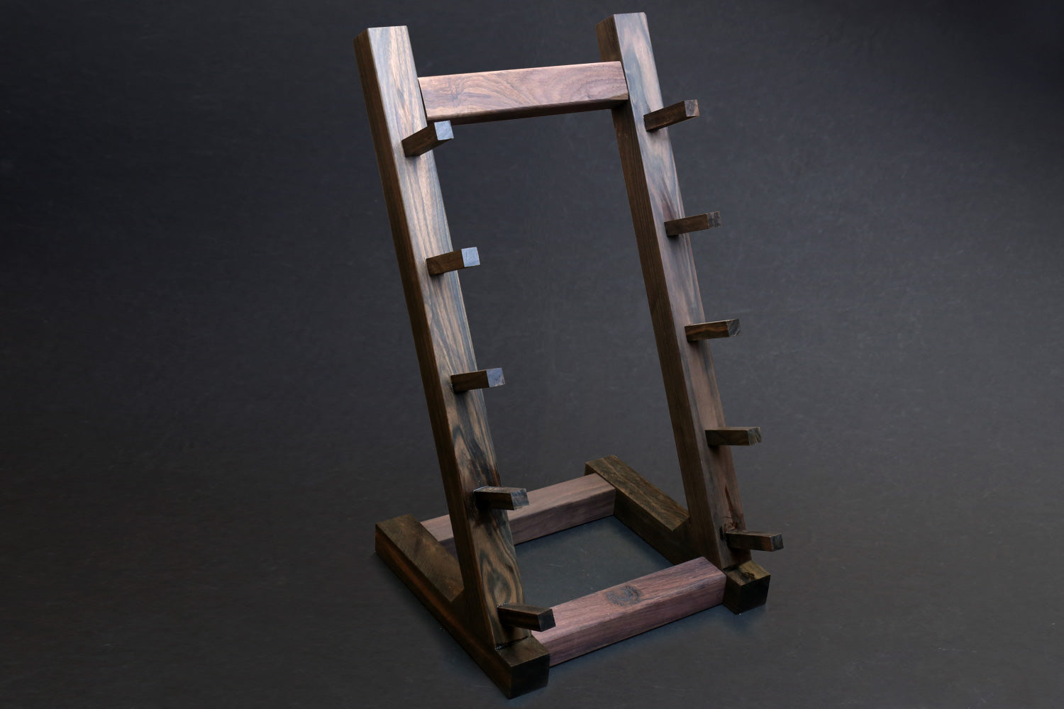 Ebony and rosewood knife rack stand with light wood top bar and evenly spaced slots