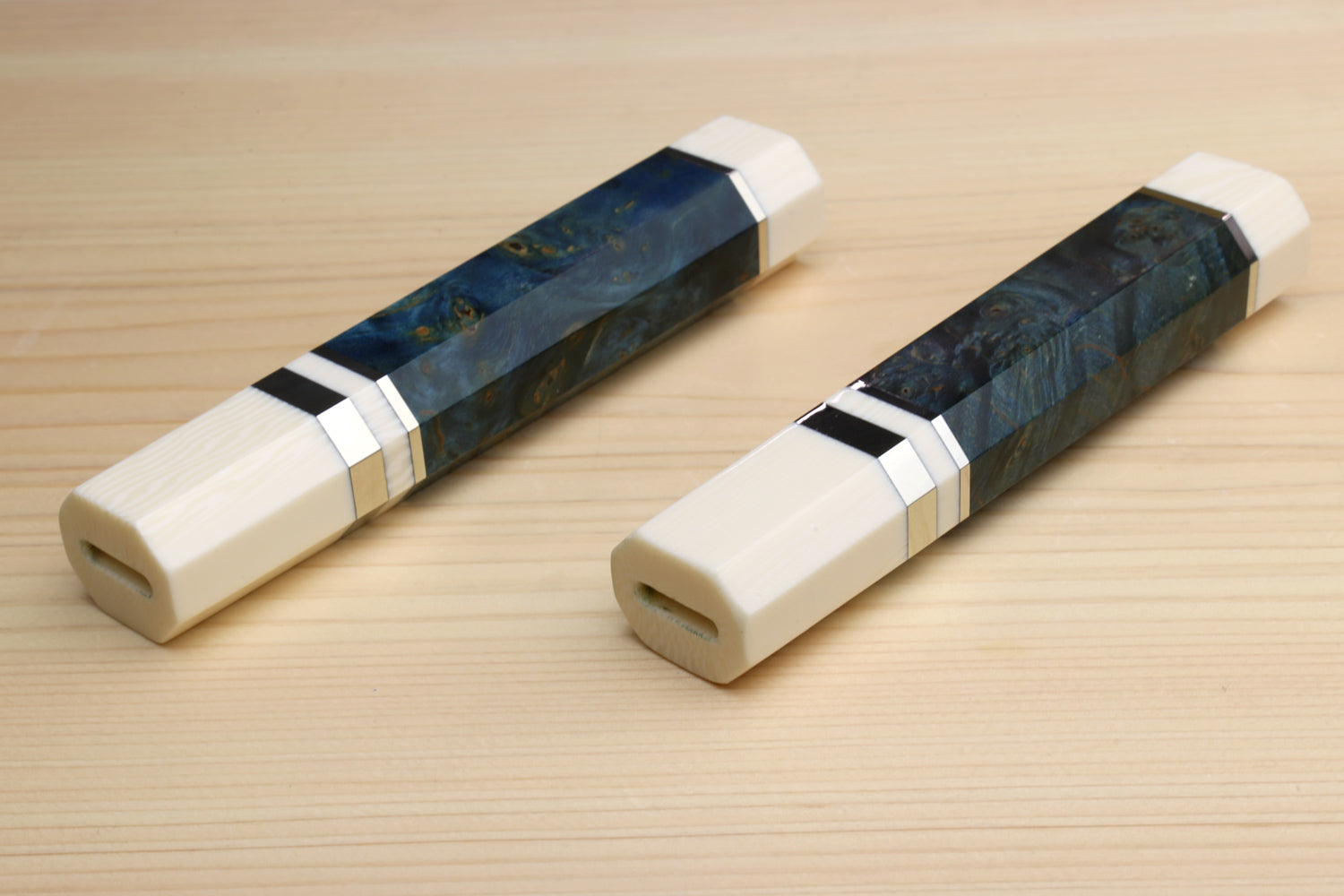 Two chef knife handle bolsters with ocean blue wrap, ivory ends, angled view