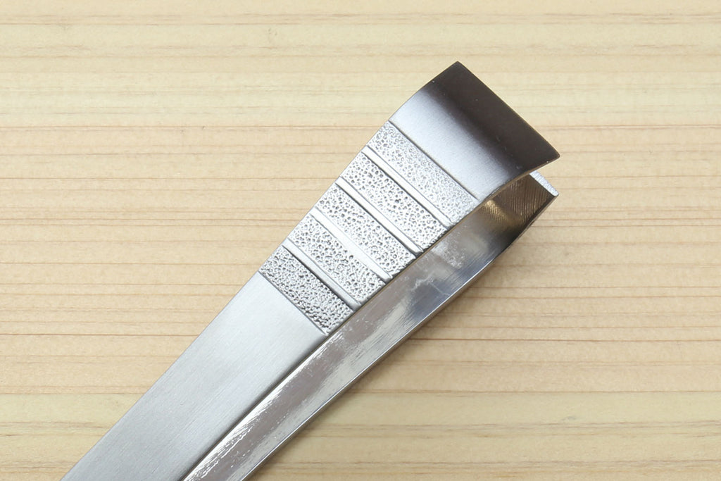 Stainless steel tweezer end with textured grip panel and open jaws
