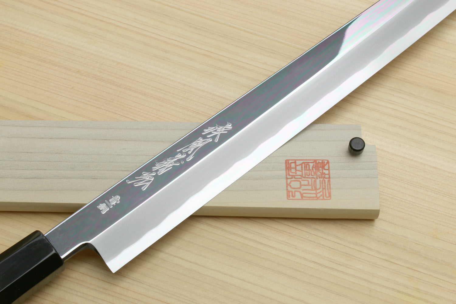 Japanese kiritsuke knife side view, mirror-finish blade with black handle