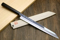 Japanese kiritsuke knife with mirror-polished blade and black ebony handle