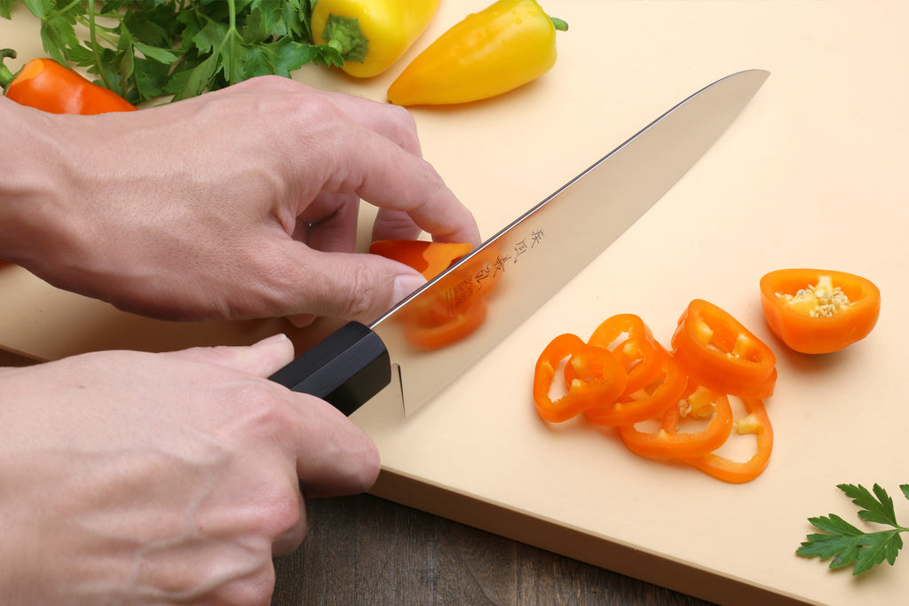 Japanese chef knife being held, stainless blade with Shitan rosewood handle