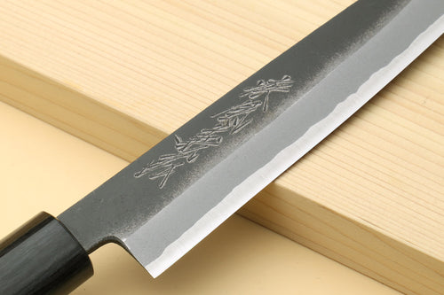 Petty knife close-up of blue steel blade with engraved markings and dark handle