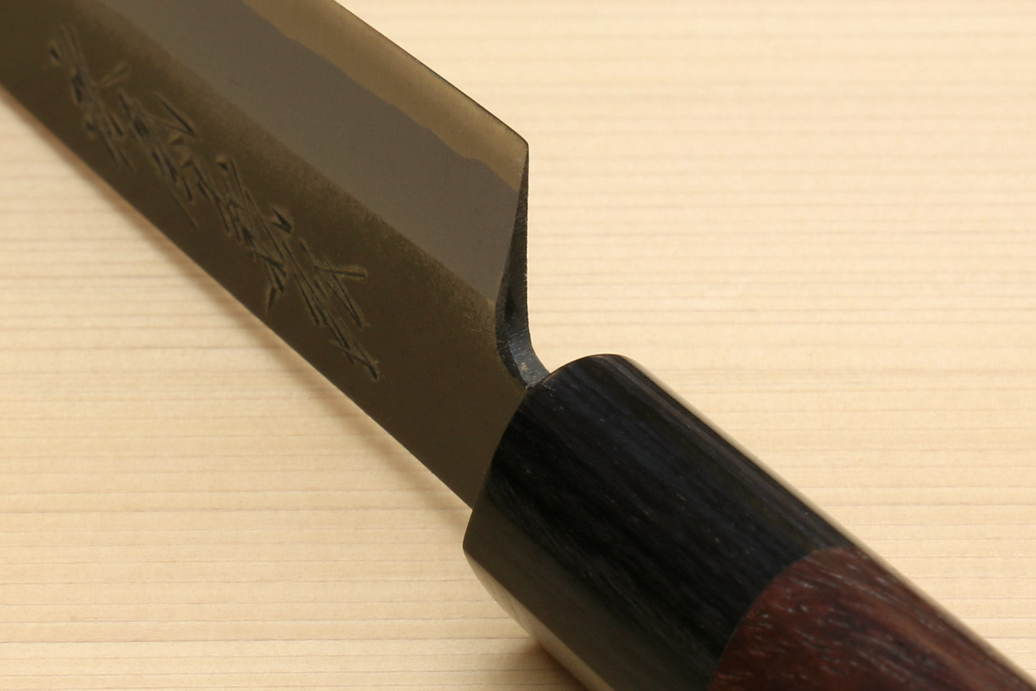 Petty knife close-up of blade heel and dark wood handle
