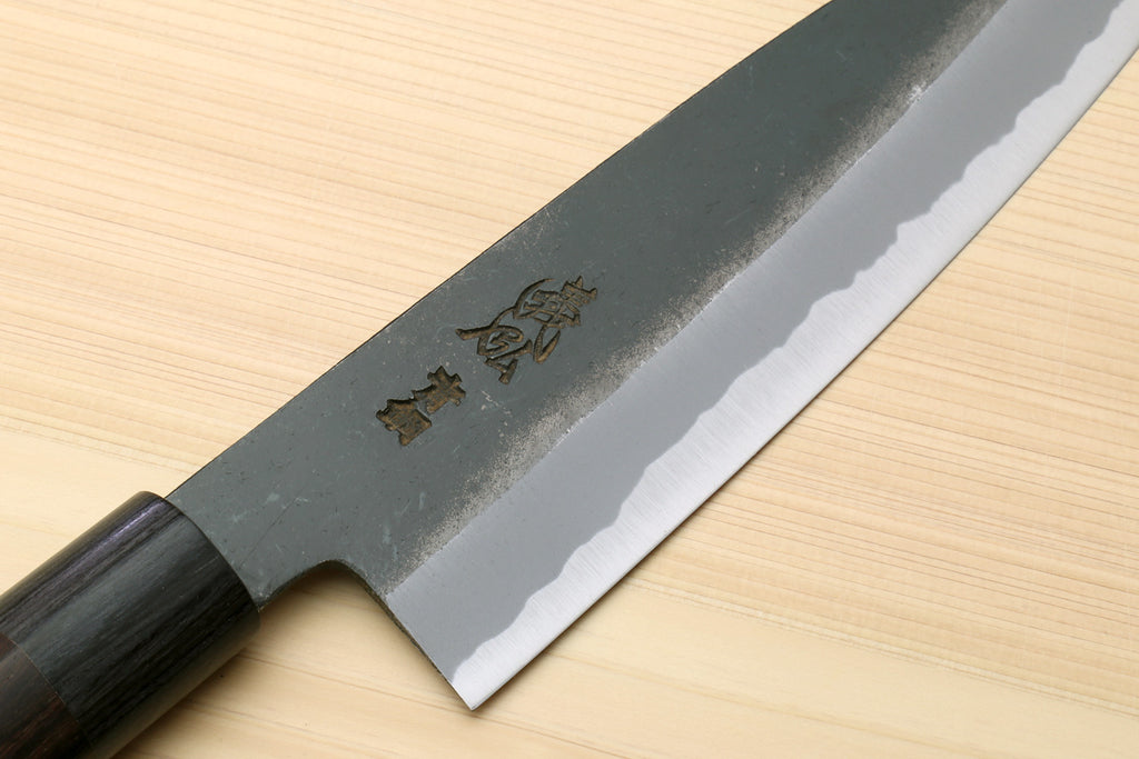 Chef knife with blackened blue steel blade, dark D-shaped handle and side markings