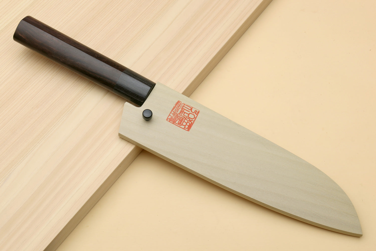 Chef knife with dark D-shaped handle and blackened blade, with saya cover