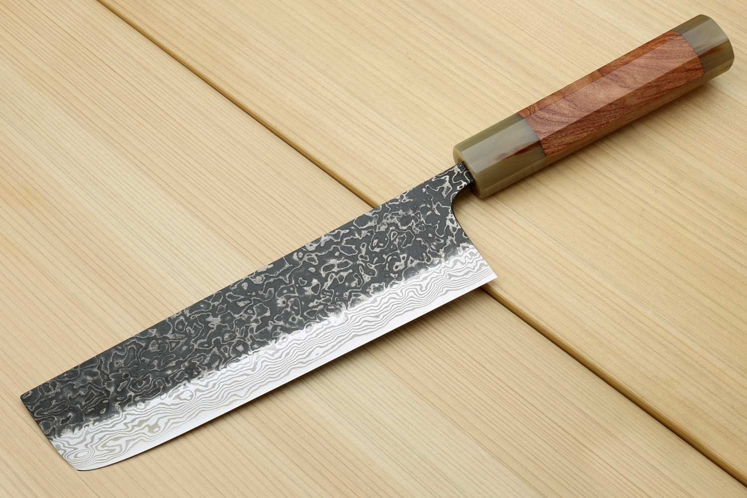 Damascus nakiri knife with ironwood handle and dark patterned steel blade