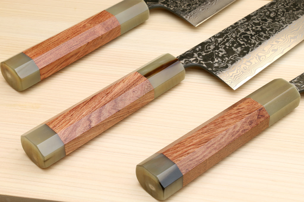 Set of Damascus santoku knives with ironwood handles and brass-toned bolsters