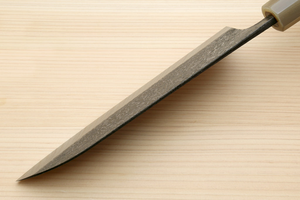 Damascus santoku blade in profile with dark spine and sharpened edge