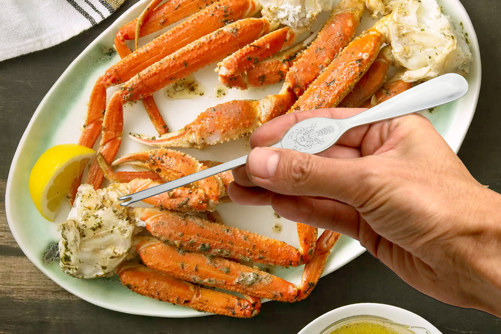 Stainless crab & lobster spoon held in hand, 7.75 in oval bowl with engraved relief