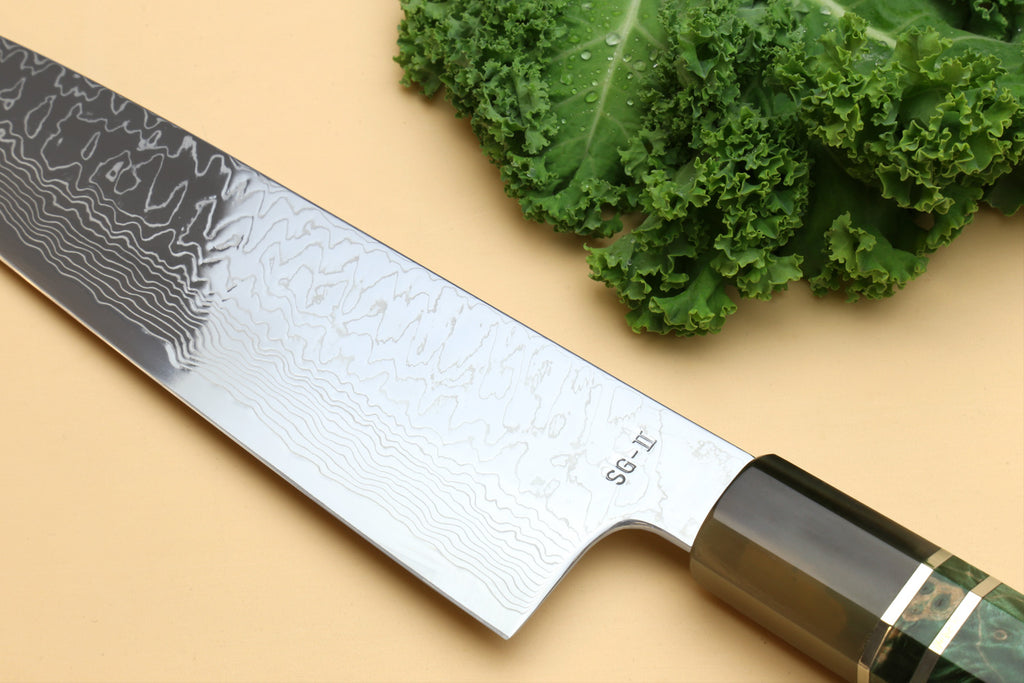 Damascus gyuto knife blade and dark green handle end, wavy pattern near heel
