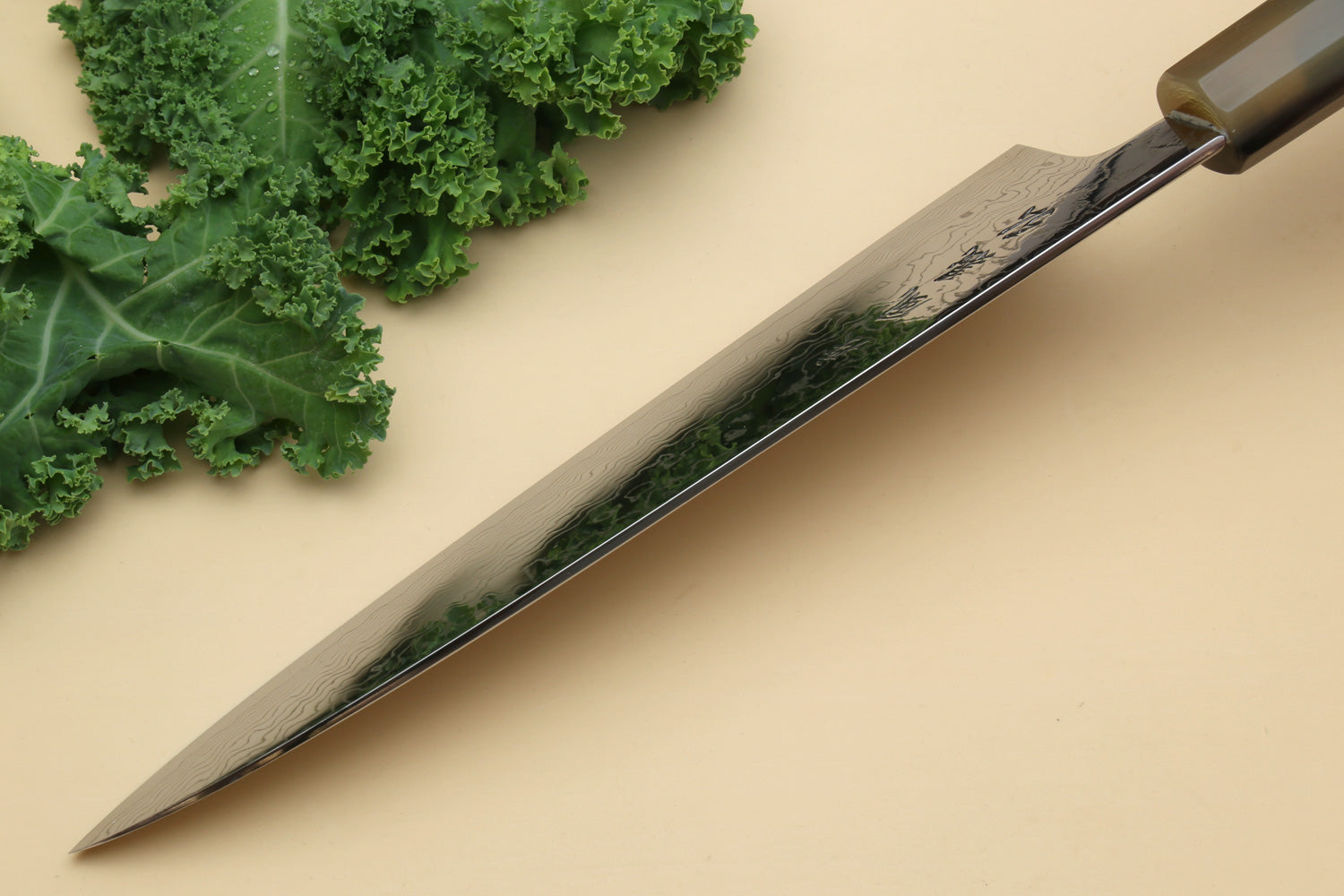 Damascus gyuto knife with long pointed blade and dark green handle, side profile