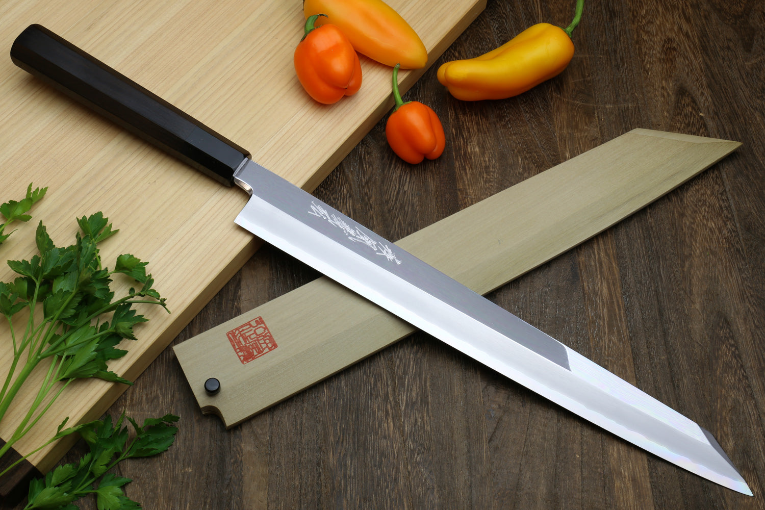 Mirror-polished Japanese Yanagi kiritsuke sushi knife with dark handle and stainless blade