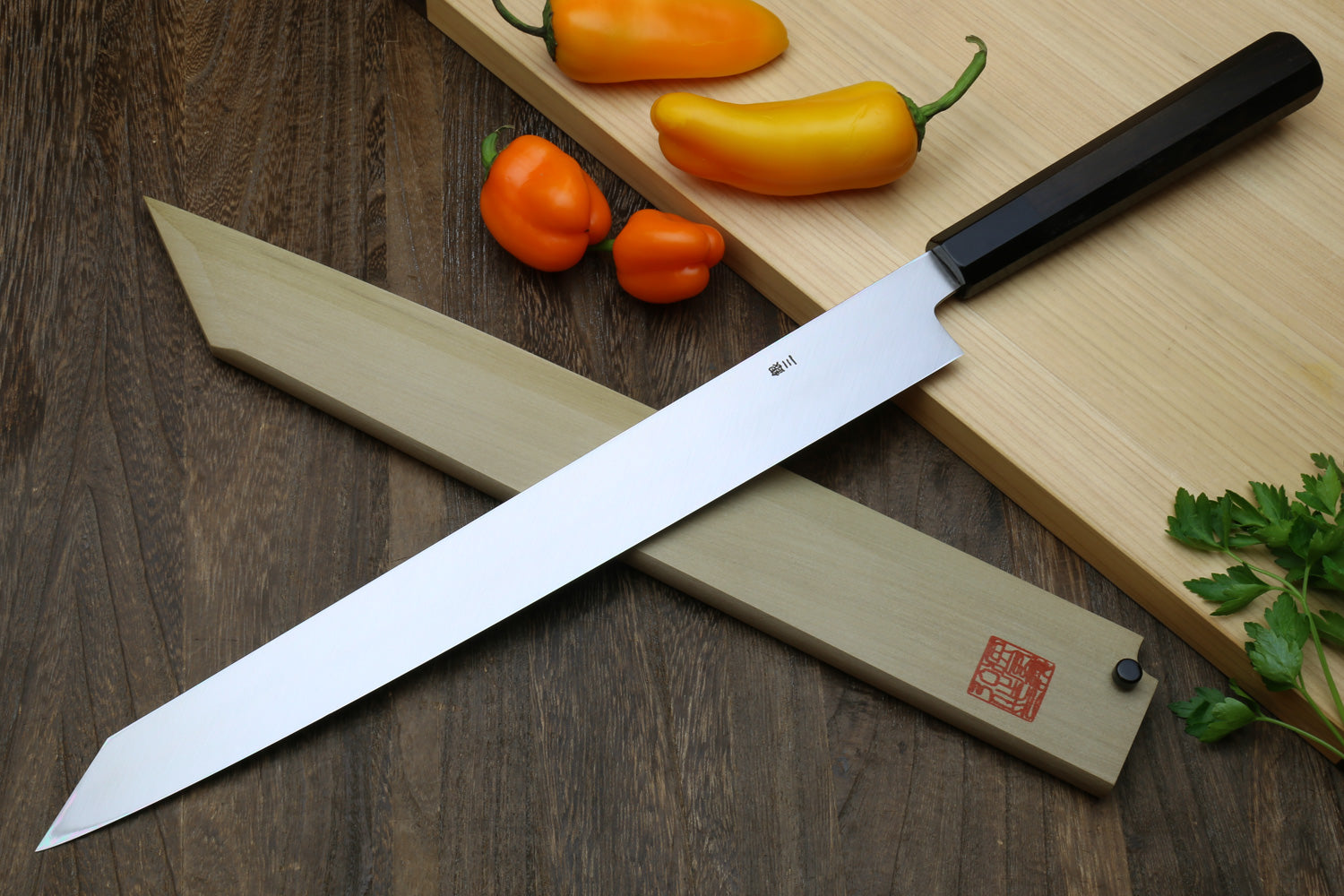 Japanese Yanagi kiritsuke knife with mirror-polished blade and dark handle