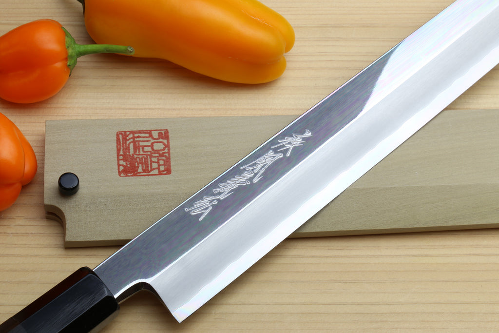 Yanagi kiritsuke sushi knife with mirror-polished blade and dark handle, etched side