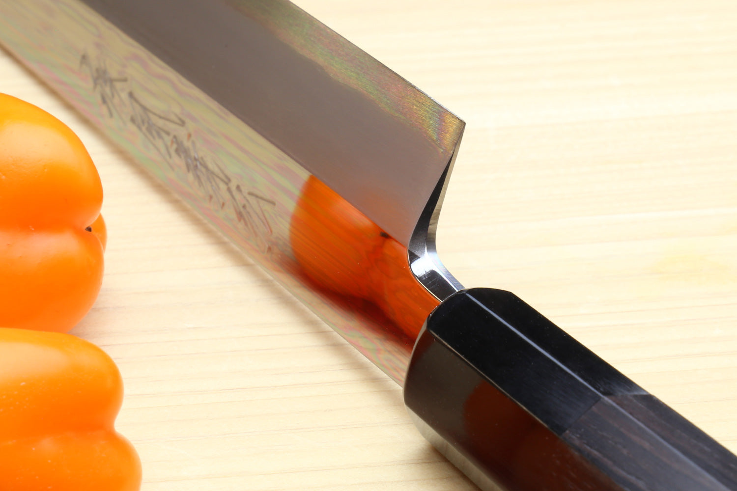 Yanagi kiritsuke knife close-up: mirror blade with etched pattern near the heel