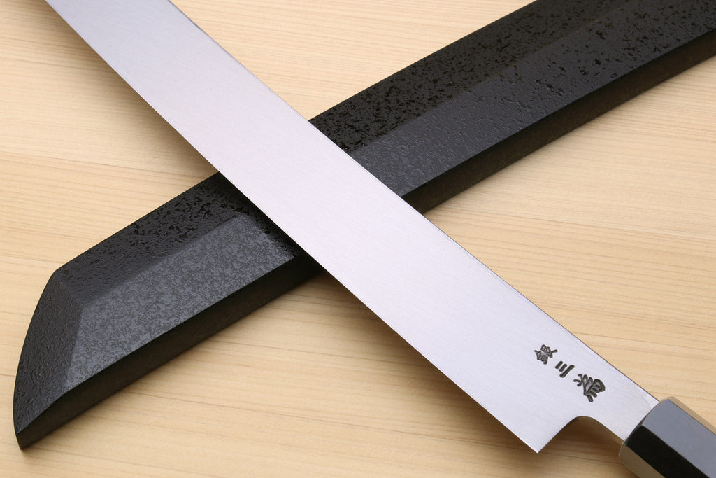 Tuna knife tip and edge detail with etched blade markings and dark handle