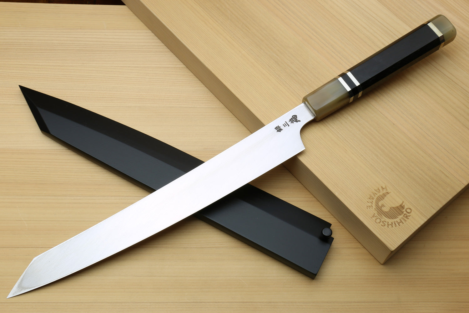 Sushi yanagiba knife with mirror stainless blade, dark handle, on gray sheath and box