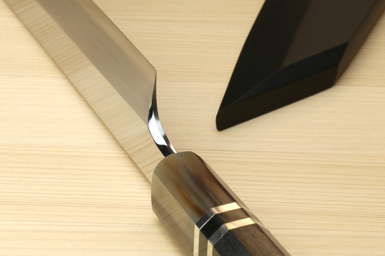 Ebony handle with striped triple-ring accents and stainless ferrule on sushi knife