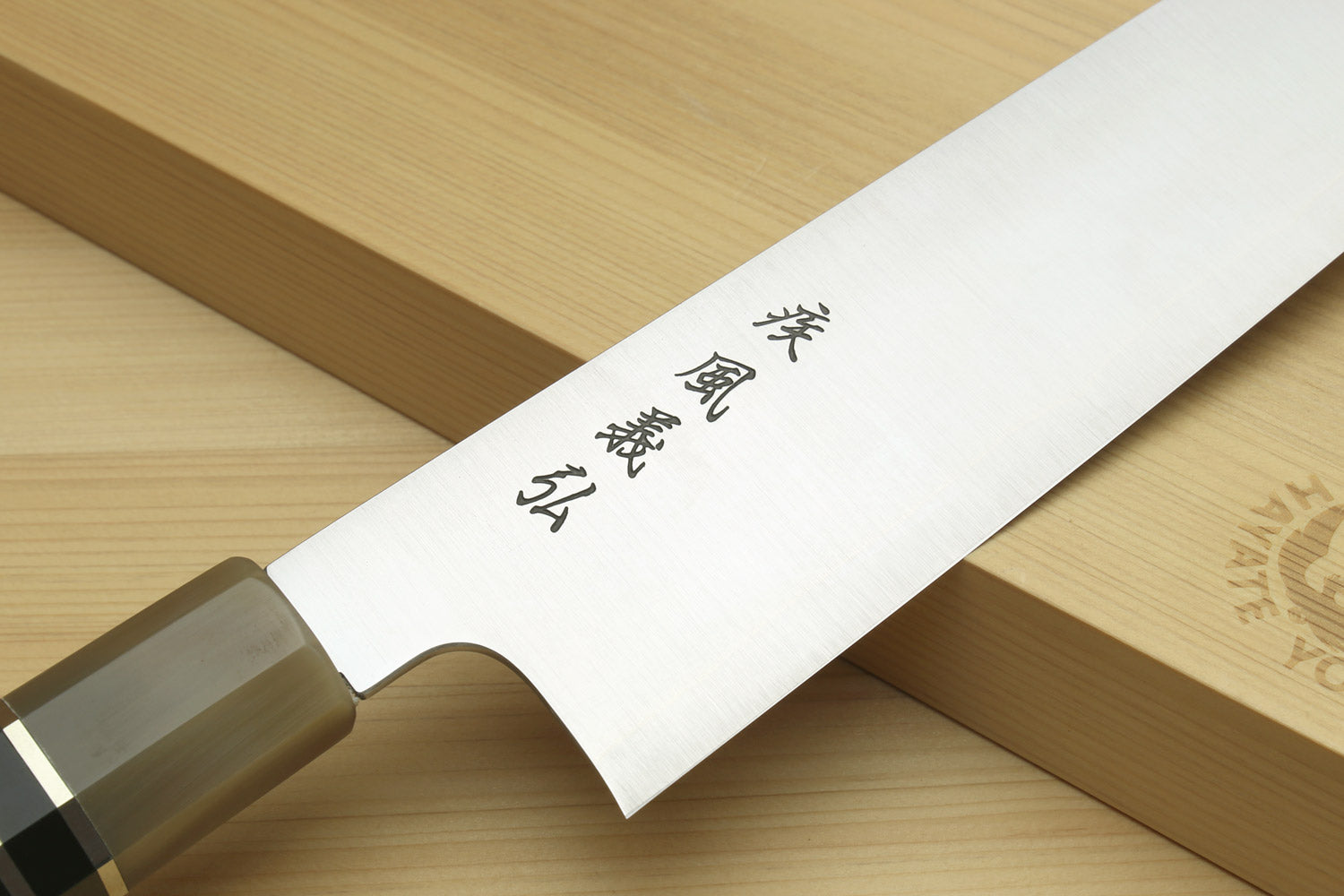 Kiritsuke chef knife blade with etched markings on stainless steel