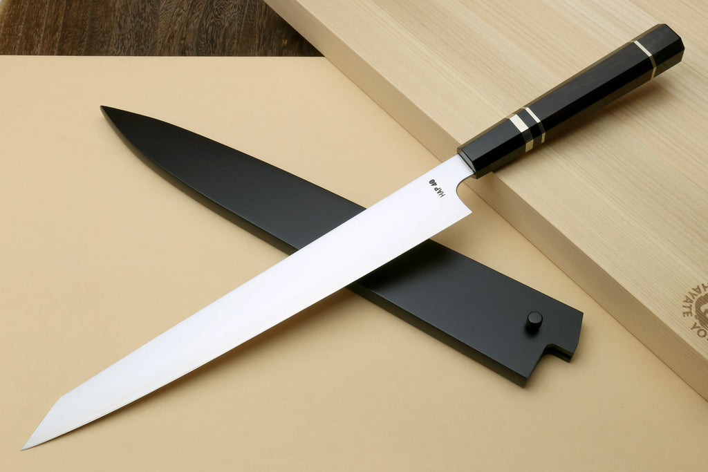 Sujihiki slicer knife with long white blade, black ebony handle, and dark guard