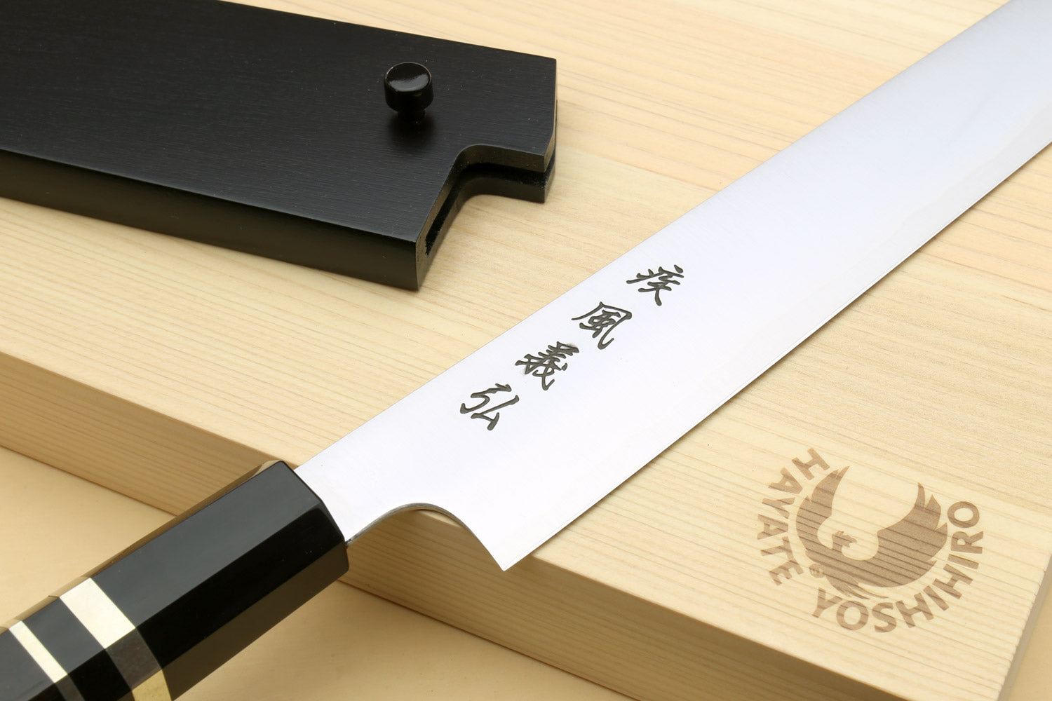Sujihiki slicer knife blade close-up with black handle and wooden gift box