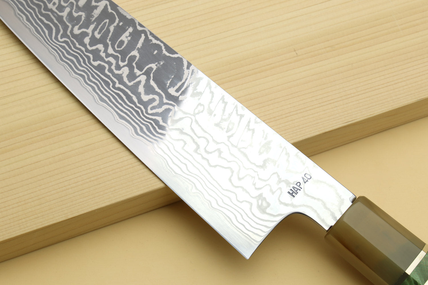 Gyuto chef knife with Damascus blade and HAP40 marking near heel