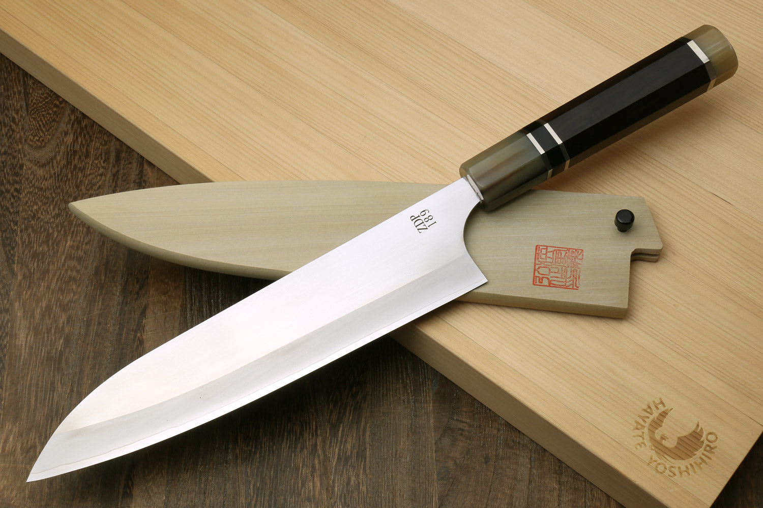 Gyuto chef knife with polished stainless blade and ebony handle, triple ring style