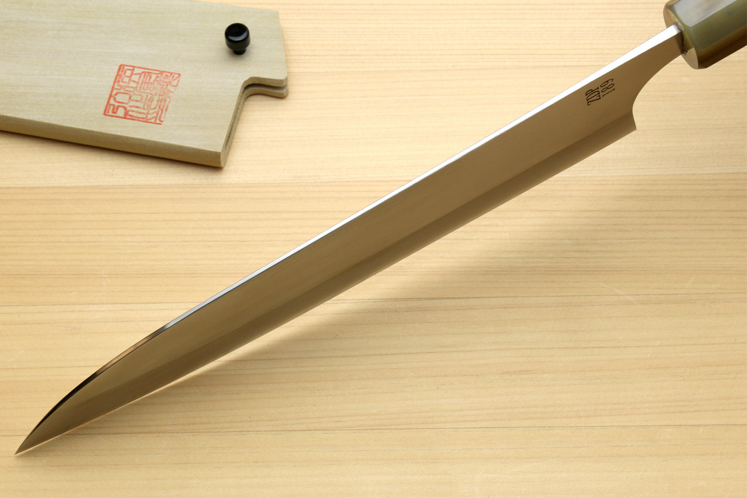Gyuto chef knife side view with pointed blade and ebony handle with ring accents